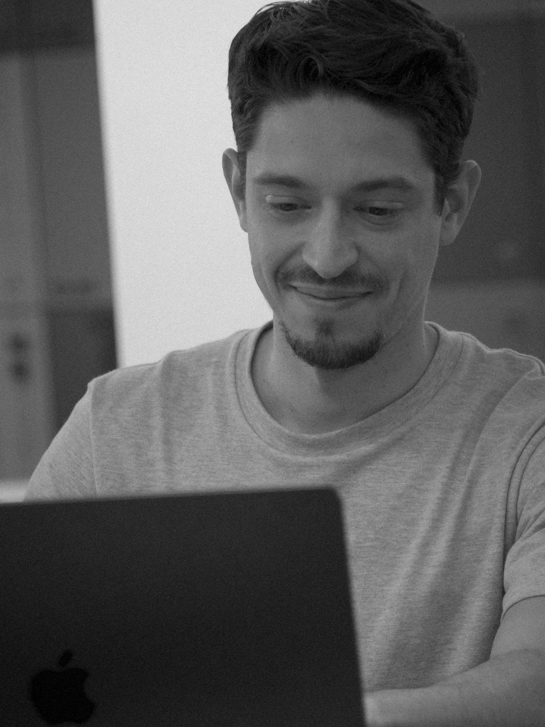 Tall frame: an engineer at his laptop, smiling at the screen