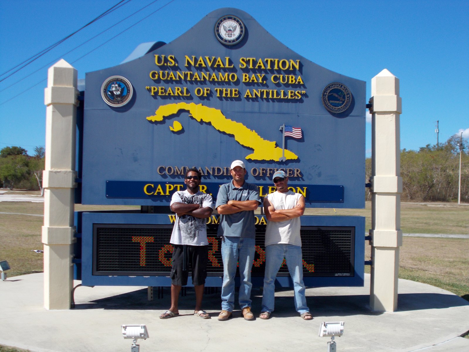 An IGS crew at the U.S. Naval Station Guantanamo Bay entrance sign