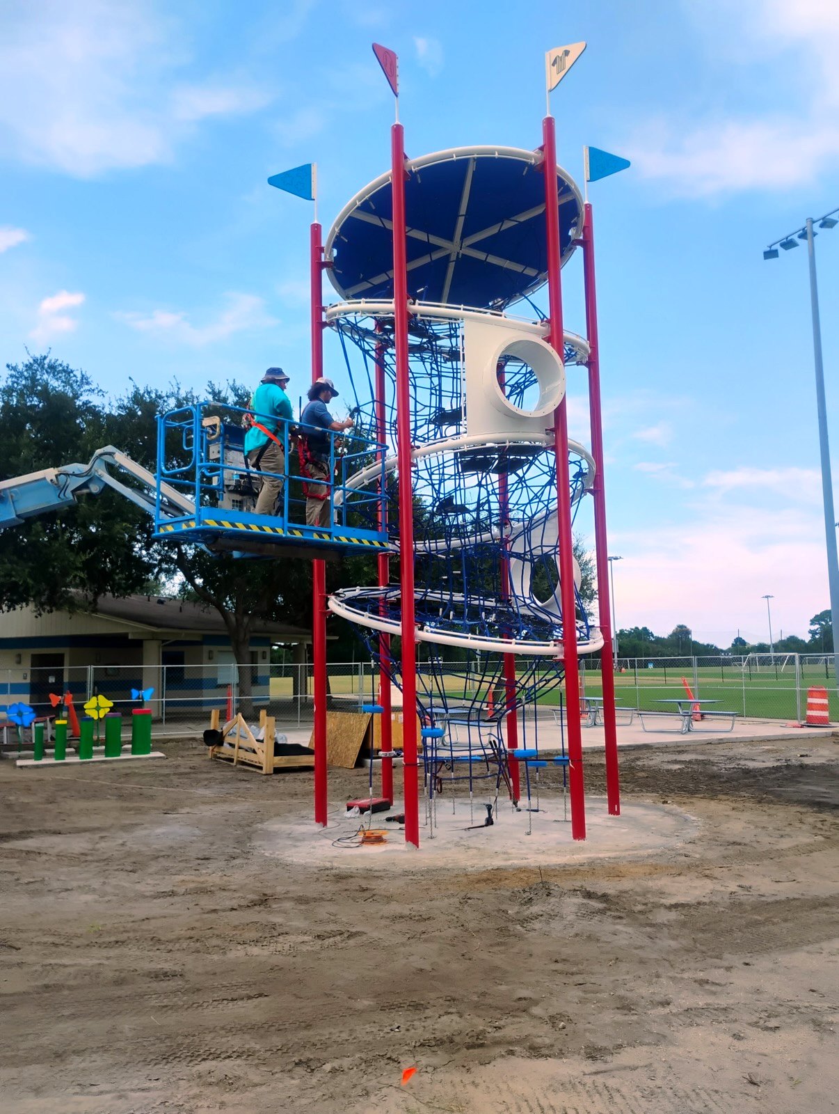 IGS installers on a boom lift installing the tower safety net at Turnbull Sports Complex