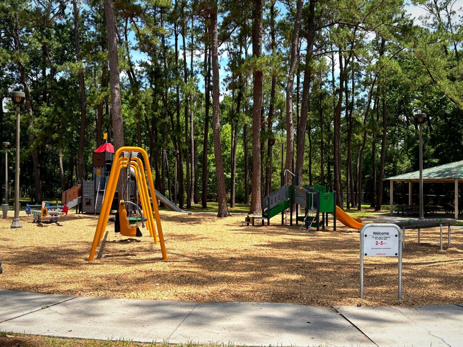 A castle-themed play structure with turret roof and stainless tube slide at Drew Park in Jacksonville
