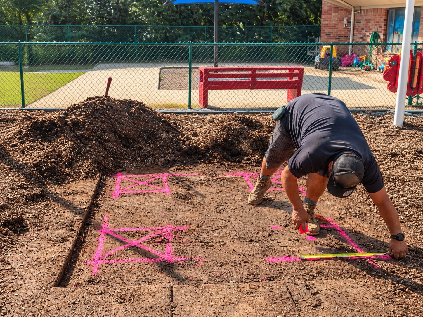 An IGS installer measuring and marking footing locations before installation