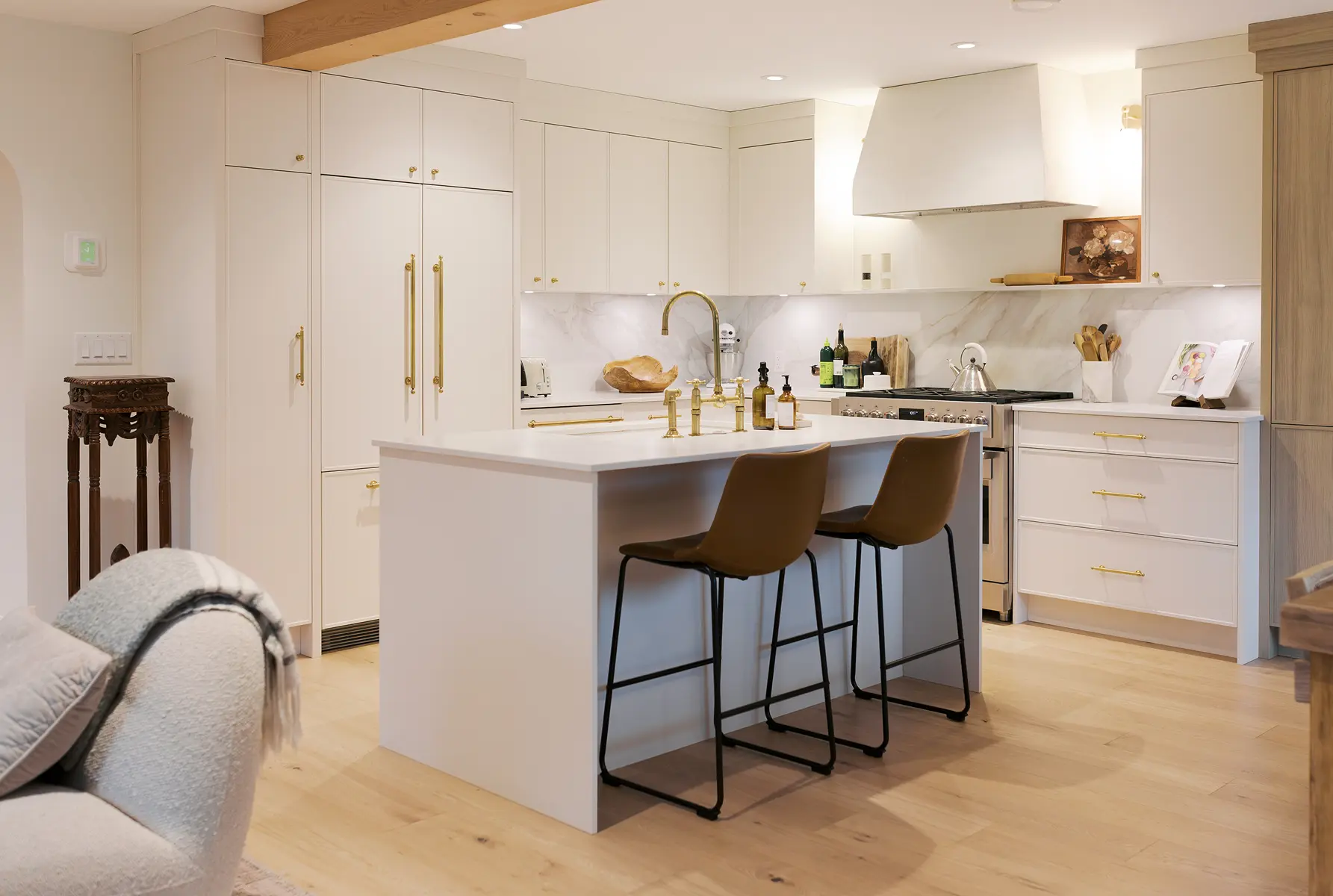 White kitchen with island, brass hardware and marble backsplash, Pemberton Heights renovation