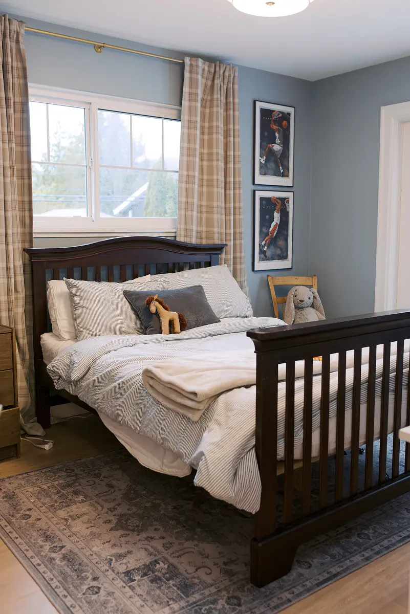 Child's bedroom with blue walls, plaid curtains and a dark wood bed, Pemberton Heights renovation