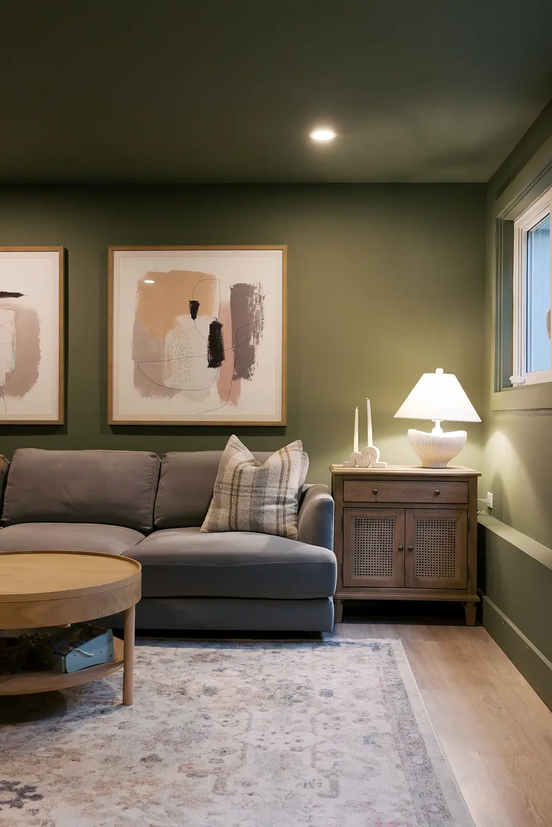 Lounge with a deep green feature wall, sectional sofa and abstract artwork, Pemberton Heights renovation