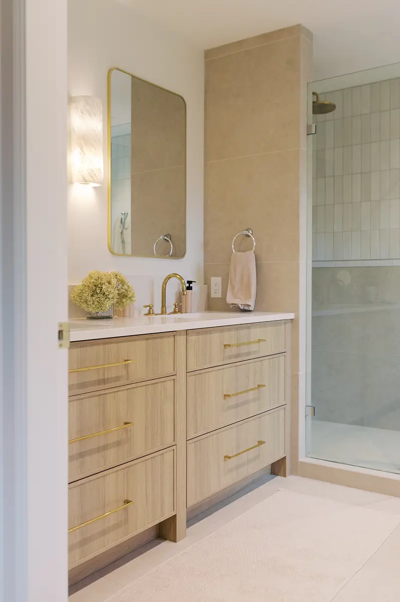 Bathroom with a light oak vanity, brass fixtures and a glass shower, Pemberton Heights renovation