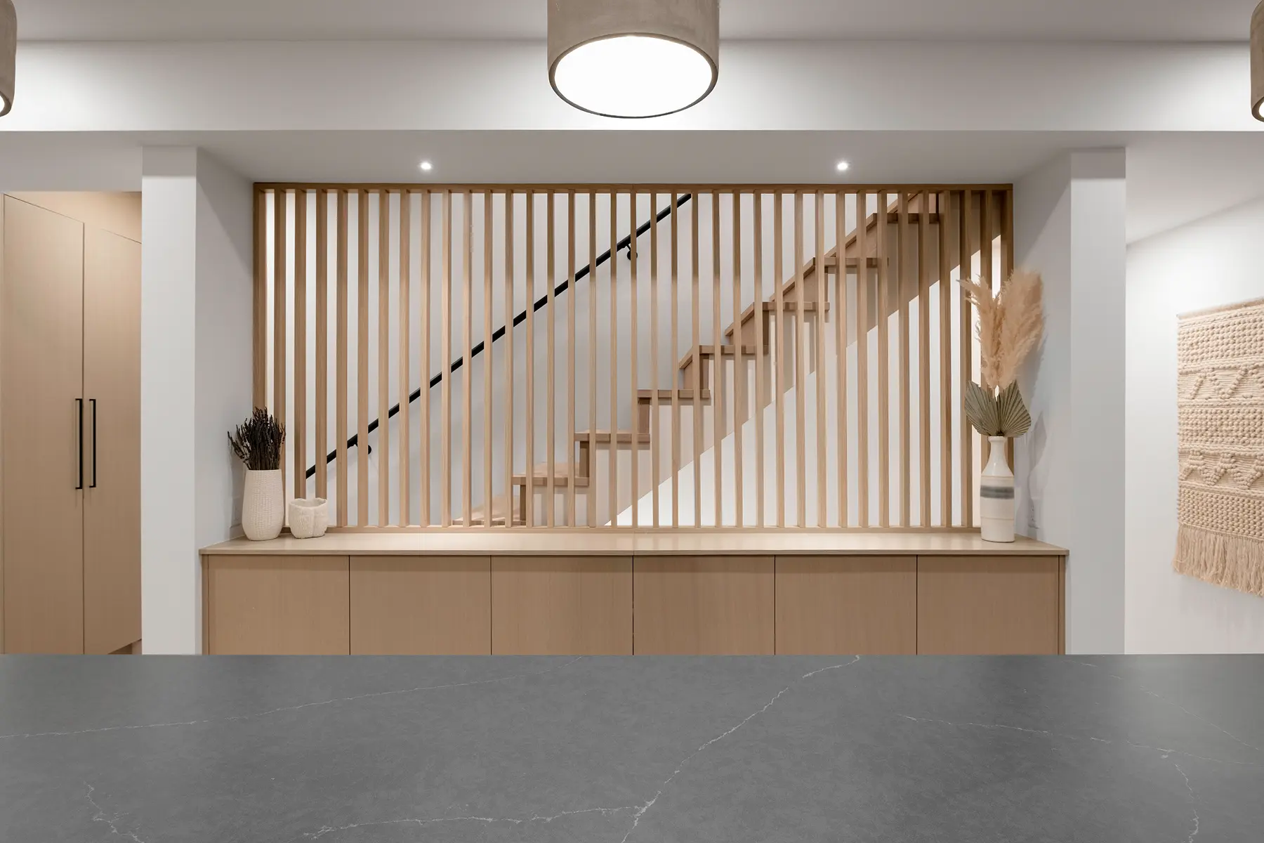 Slatted oak stair screen above built-in cabinetry, 4th Street duplex