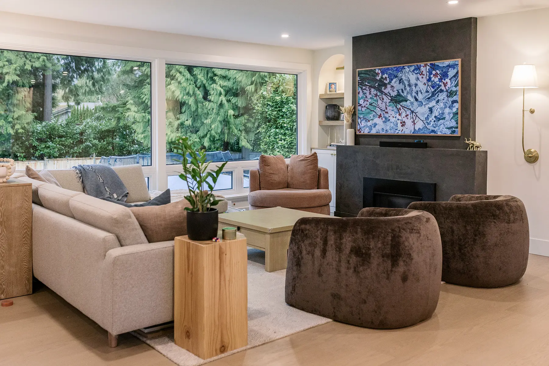 Living room with a sectional sofa, plush swivel chairs and a dark fireplace wall, Pemberton Heights renovation