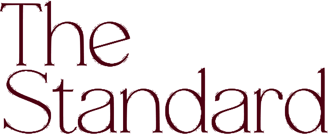 The Standard wordmark text in a dark red serif font.