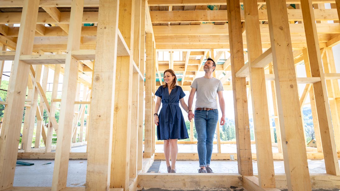 Couple holding hands inside their new home under construction