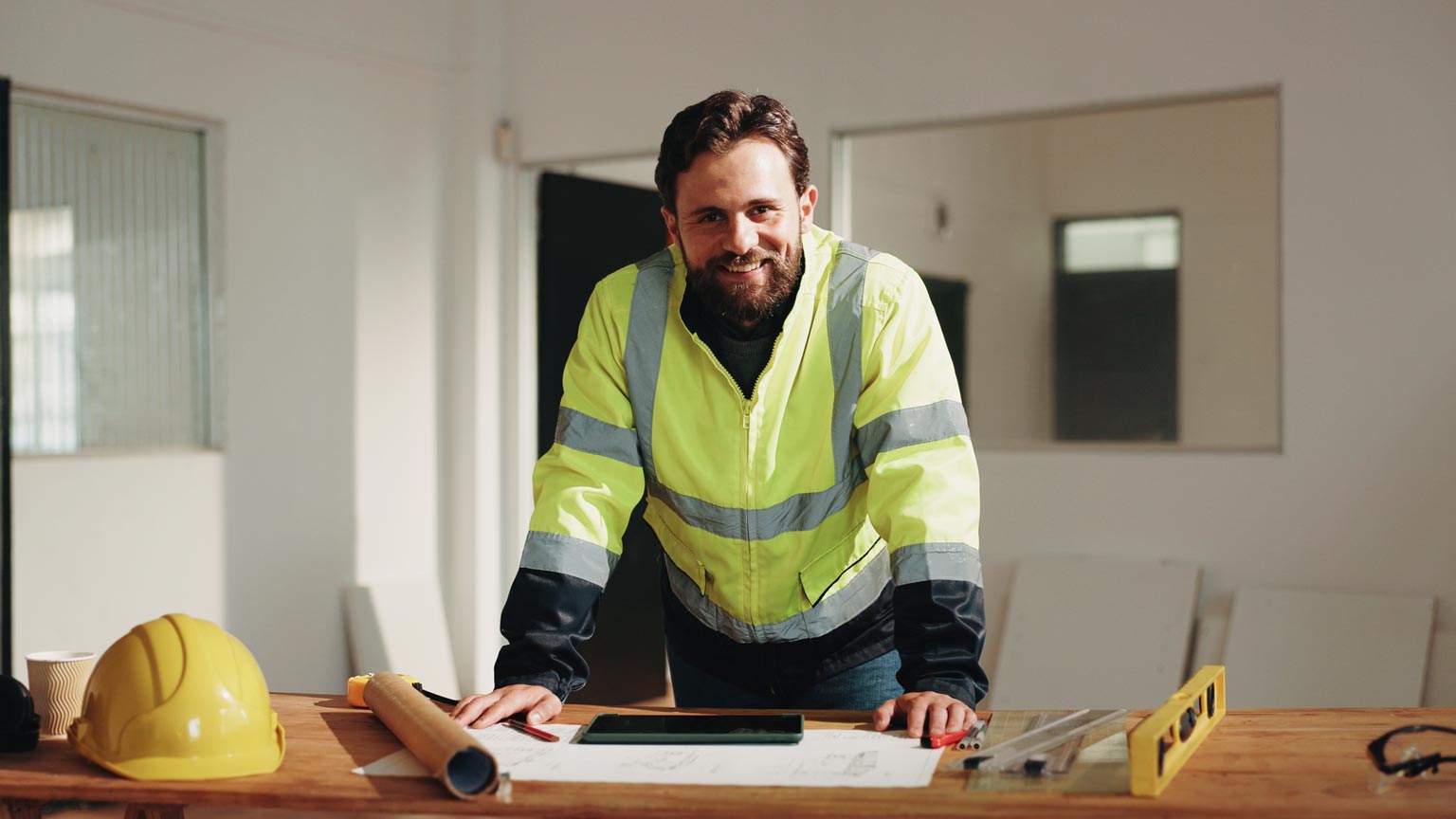 Smiling engineer in a high visibility vest on a Queensland build site