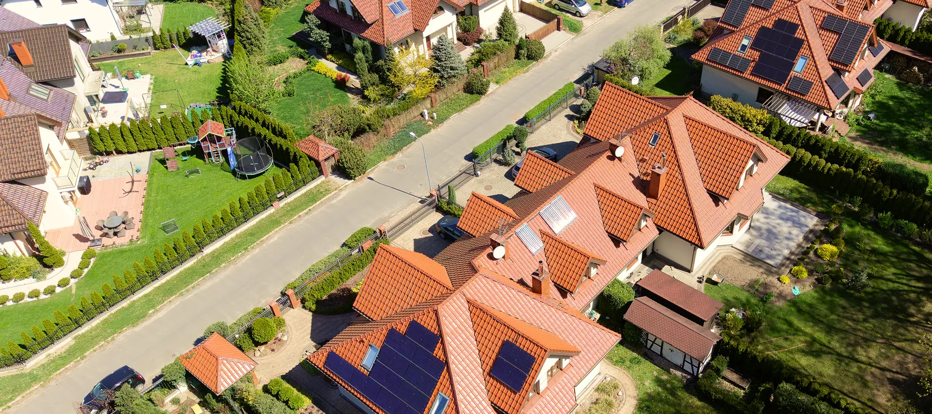 Luftaufnahme eines Wohngebiets mit Photovoltaikanlagen auf den Dächern