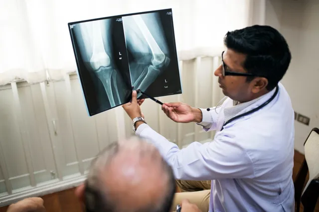 Consultant reviewing a knee X-ray with a patient