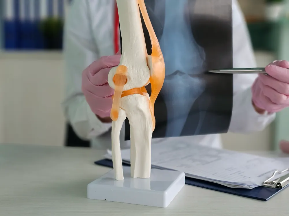 Consultant reviewing knee MRI scans with a patient