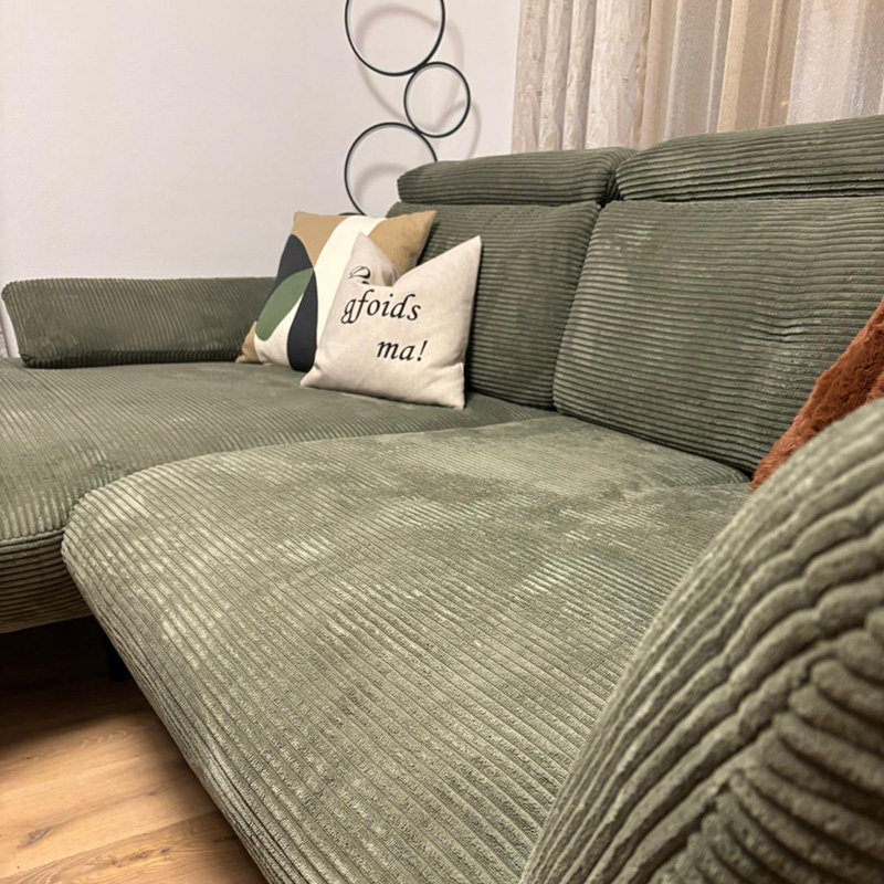 Grünes Cord-Ecksofa mit Kissen in einem Kundenwohnzimmer