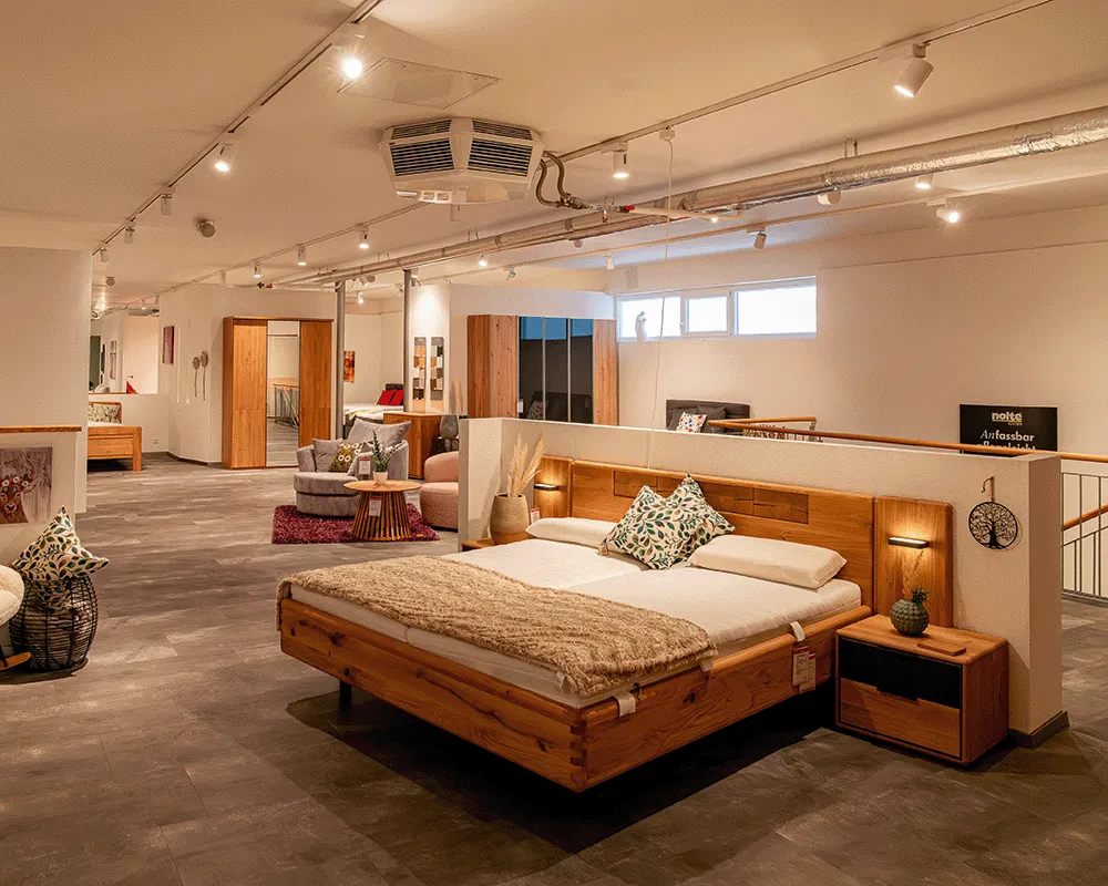 Schlafzimmer mit Massivholzbett in der Ausstellung