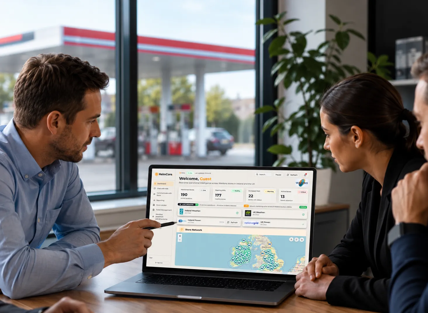 man and woman at a desk overlooking forecourts, on a computer looking at entire retail estate 