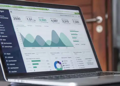 Laptop on a desk showing an analytics dashboard with traffic charts and stats
