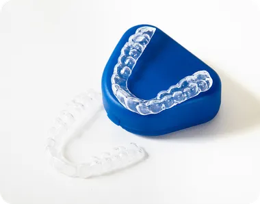 Clear retainer resting on a blue retainer case
