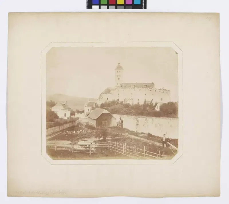 Frühe Fotografie von Andreas Groll, um 1854: die Schallaburg mit Turm auf einer Anhöhe, davor Häuser und ein Zaun