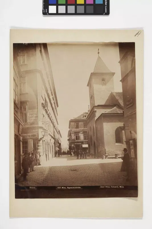 Fotografie um 1890: eine Gasse mit Häusern und Passanten, am Ende der Turm der Ruprechtskirche