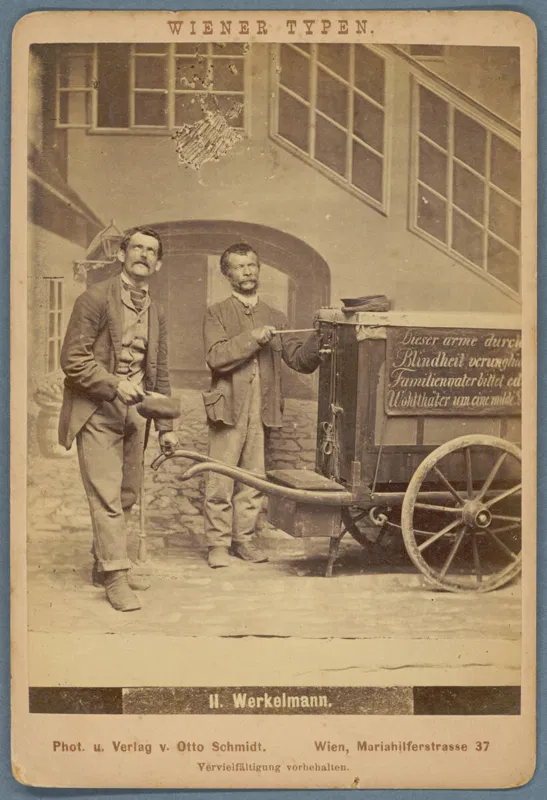 Fotografie: zwei Männer stehen in einem Hof neben einem Leierkasten auf einem Karren mit großen Rädern, oben der Aufdruck Wiener Typen, unten 11. Werkelmann