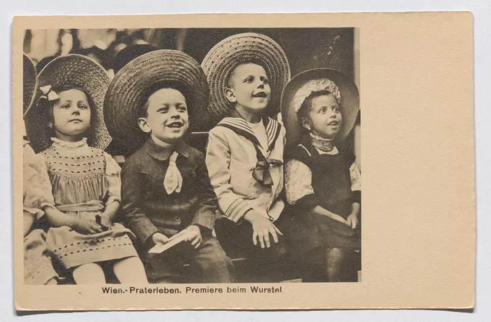 Ansichtskarte um 1908: vier lachende Kinder mit großen Strohhüten, ein Bub im Matrosenanzug, sie schauen gebannt nach oben