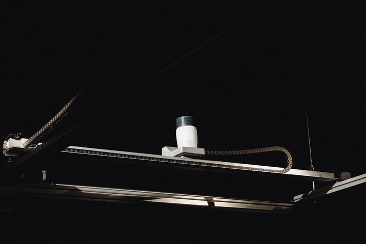 Die Mechanik von watermap mit dem Wassertank über der Sandkarte, im Dunkeln beleuchtet