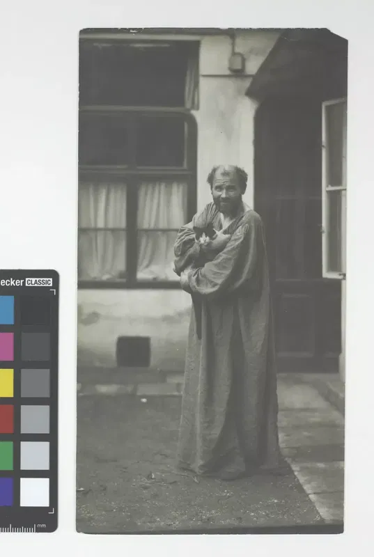 Moriz Nähr, Gustav Klimt im Ateliermantel mit einer Katze im Arm, Fotografie um 1911