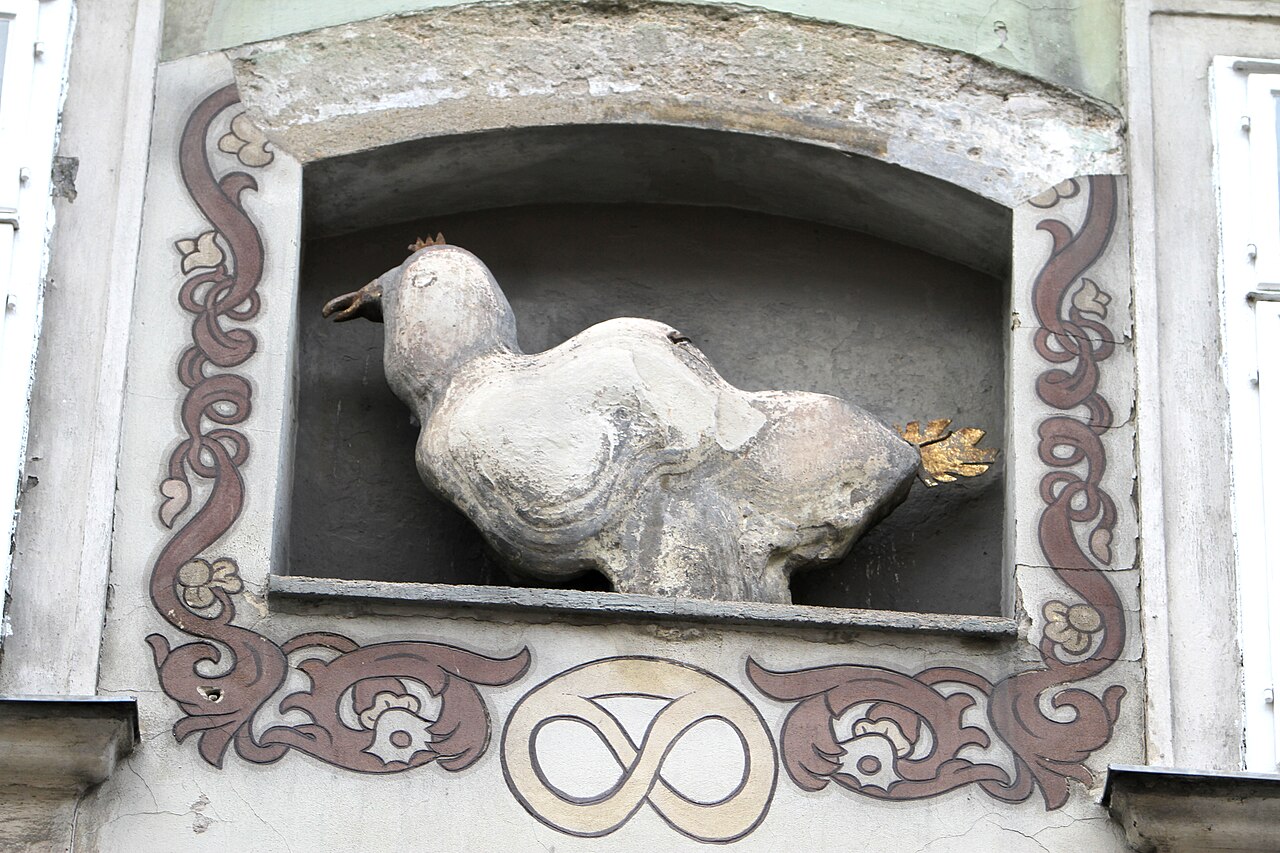 Die steinerne Basiliskenfigur in einer Nische an der Fassade des Hauses Schönlaterngasse 7