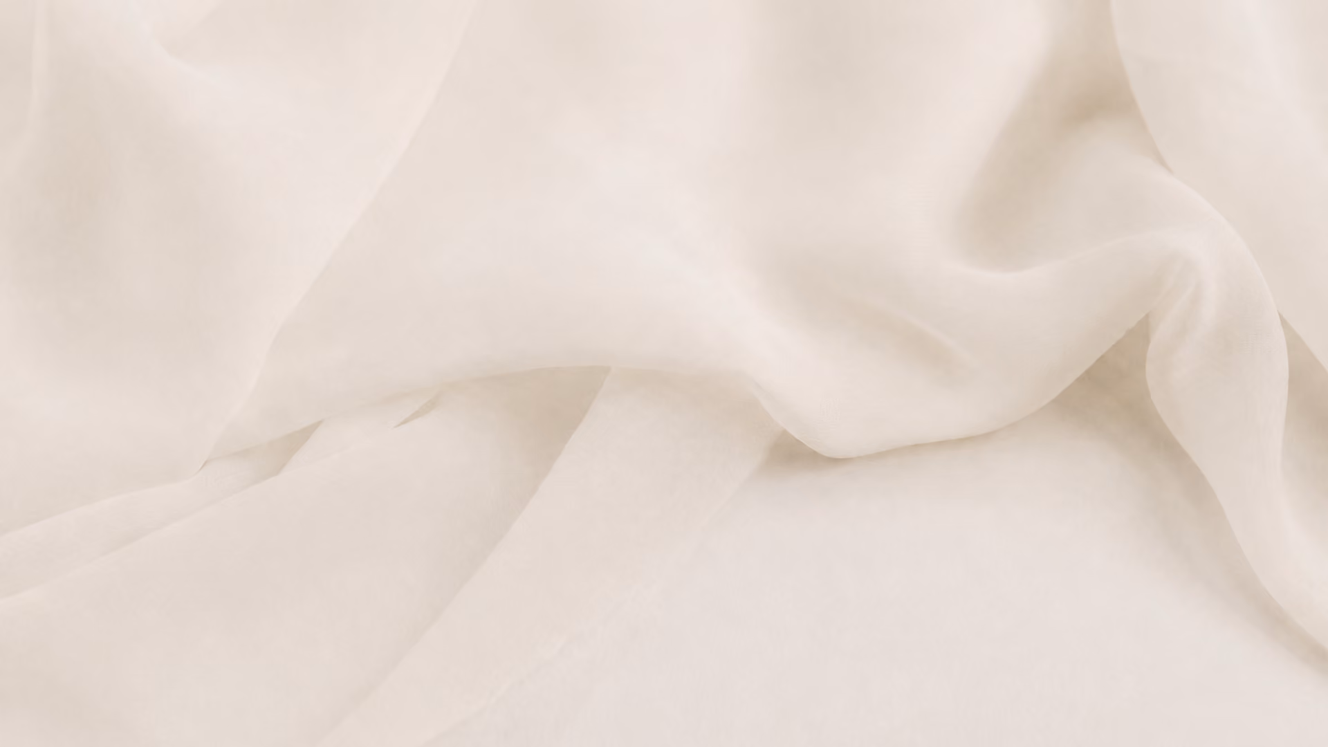 Soft, light beige fabric with gentle folds and a smooth, translucent texture.