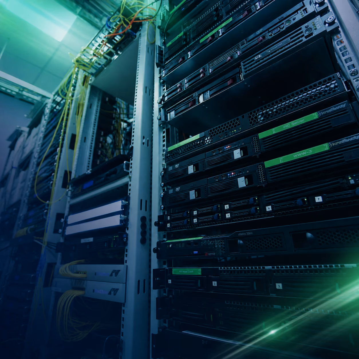 Serverrek met netwerkhardware en verbonden gele datakabels in datacenteromgeving.