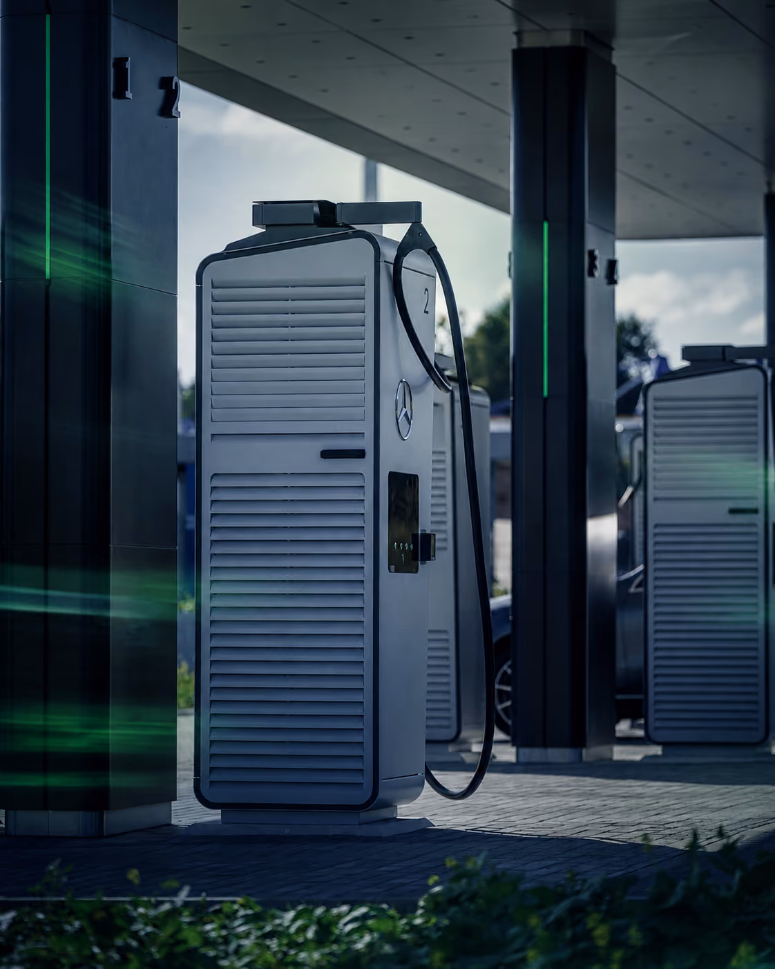 Oplaadstations voor elektrische voertuigen met het Mercedes-logo, geplaatst onder een overkapping bij een laadstation.