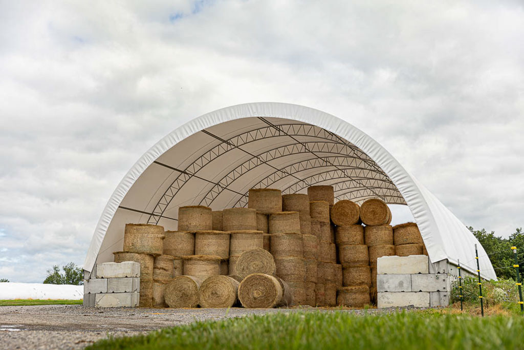 hay storage in a white thundura fabric structure with concrete block base
