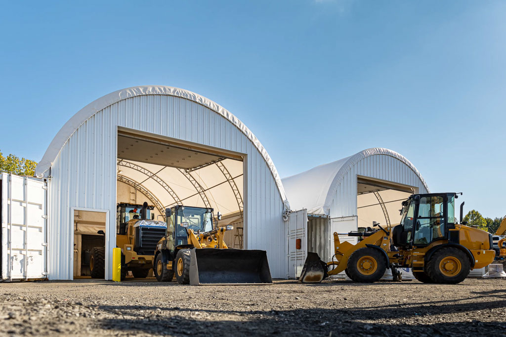 payloaders sitting in front of a thundura hoop building with roll doors in the end