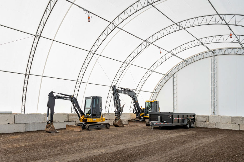 thundura fabric structure used for excavator and trailer storage.