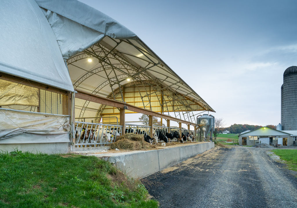 Thundura fabric structure with awning and feeding station for cattle