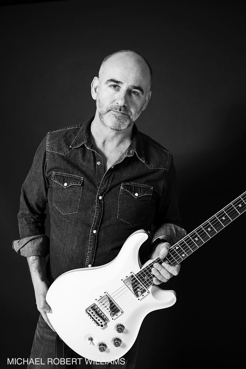 Rob Harris holding a white PRS guitar