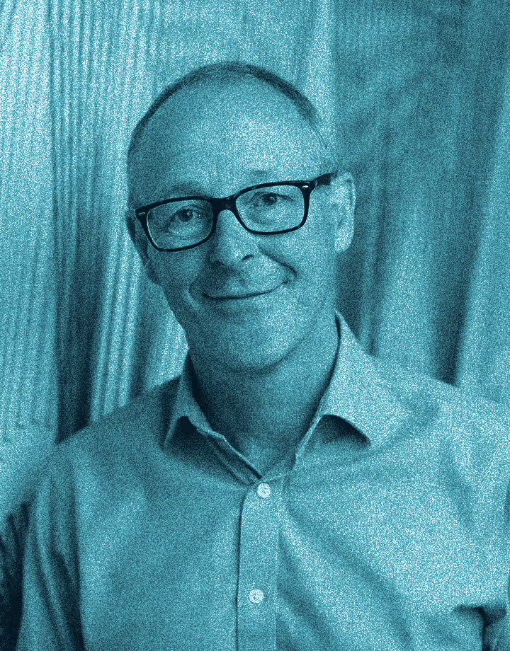 an image of a man smiling wearing glasses
