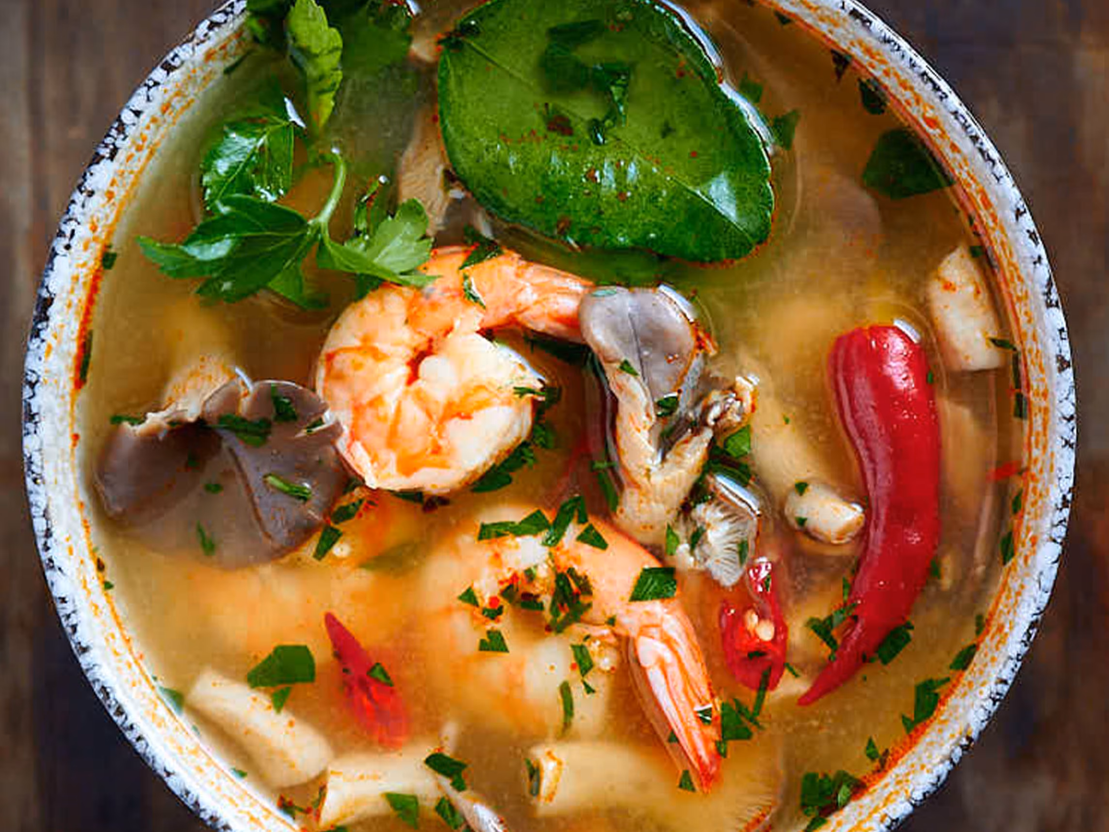 Tom yum soup with shrimp, lemongrass, mushrooms and lime leaves