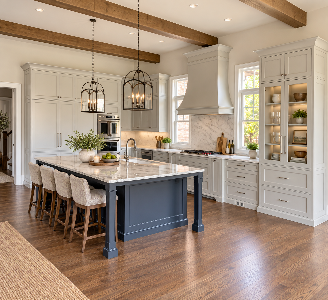 Transitional kitchen with light gray painted cabinetry, a navy island, glass-front display cabinet and custom range hood