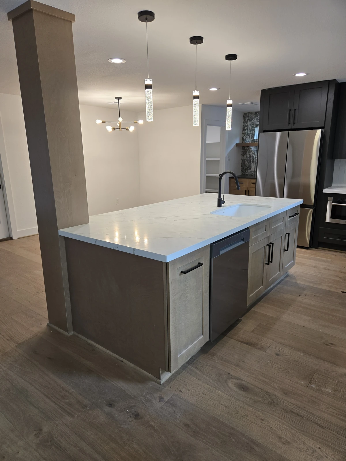 Quartz topped island with pendant lighting in an open plan Houston kitchen remodel