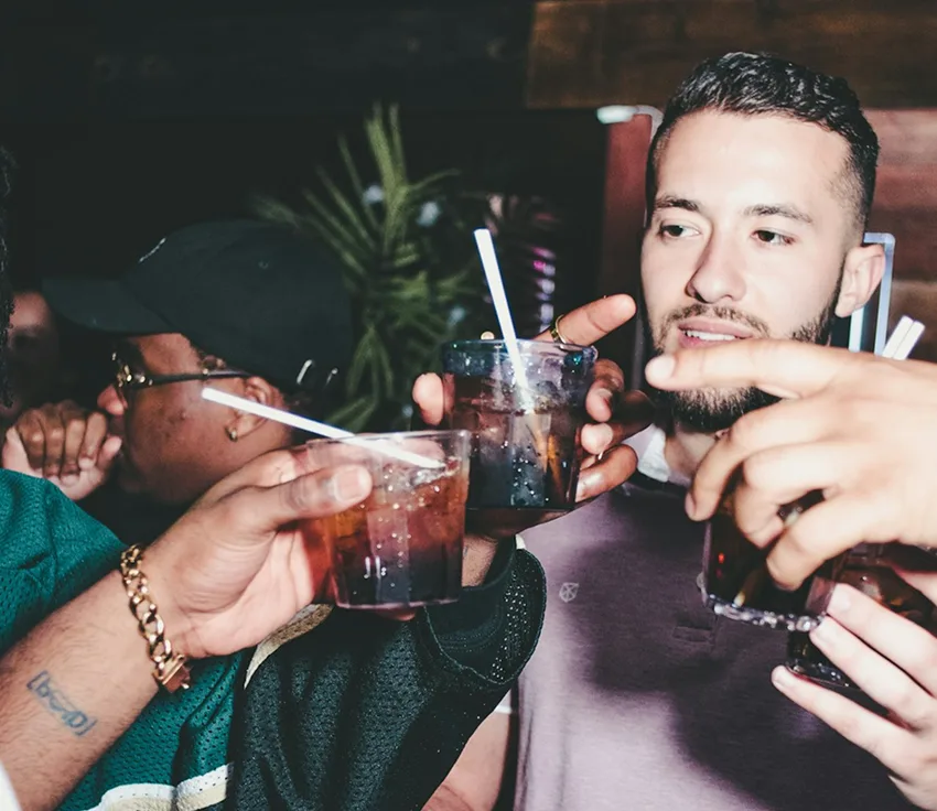 Friends toasting cocktails together at a nightlife venue