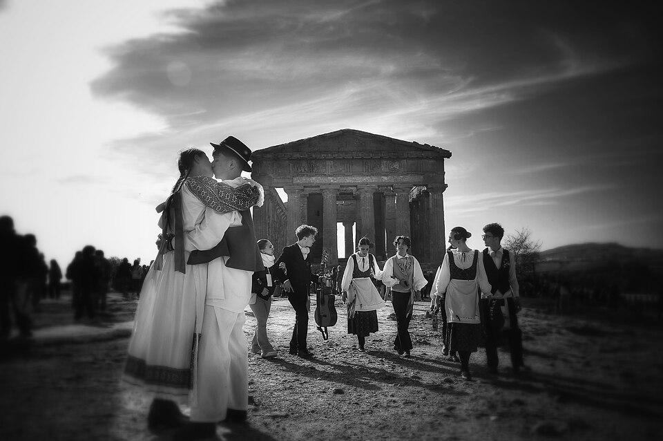 A couple embracing among folk dancers in Agrigento, Sicily
