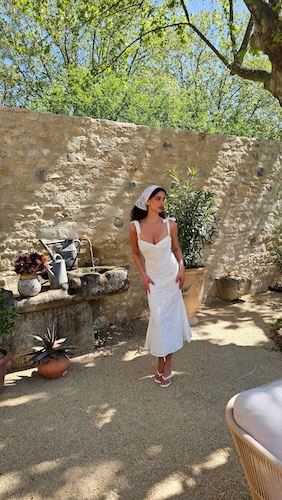 Woman in a white dress in a rustic Mediterranean courtyard