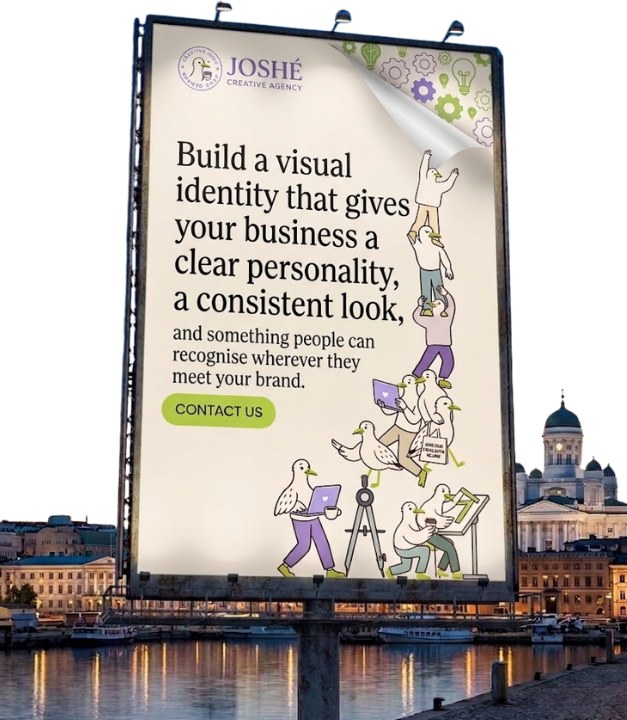 Mainosjuliste, jossa lukee: "Build a visual identity that gives your business a clear personality, a consistent look, and something people can recognise wherever they meet your brand." Julisteella on myös kuva seitsemästä ankan näköisestä hahmosta, jotka työskentelevät yhdessä eri tehtävissä, kuten kannettavalla tietokoneella, piirustuslaudalla, ja kiipeävät toistensa päälle muodostaen ketjun. Julisteessa lukee painikkeena "CONTACT US". Yläkulmassa on yrityksen logo ja nimi: JOSHÉ Creative Agency. Taustalla näkyy kaupunki vesistön rannalla iltahämärässä.