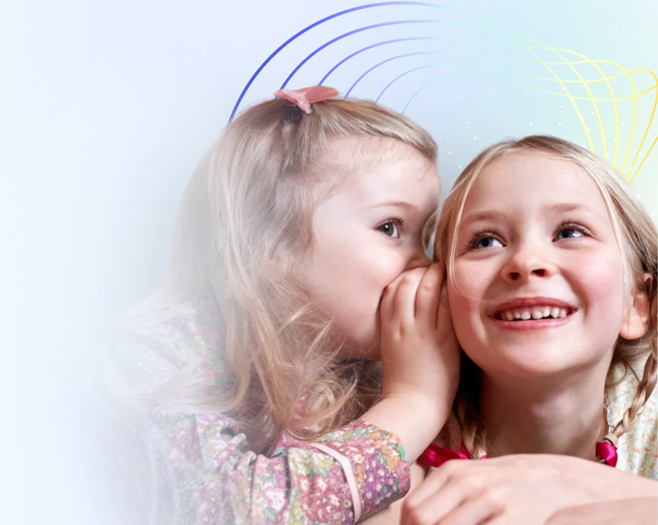 Two young girls with playful expressions, one whispering in the other's ear