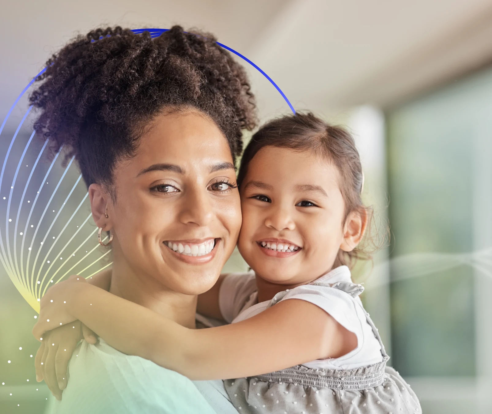 Mother holding young daughter, both smiling