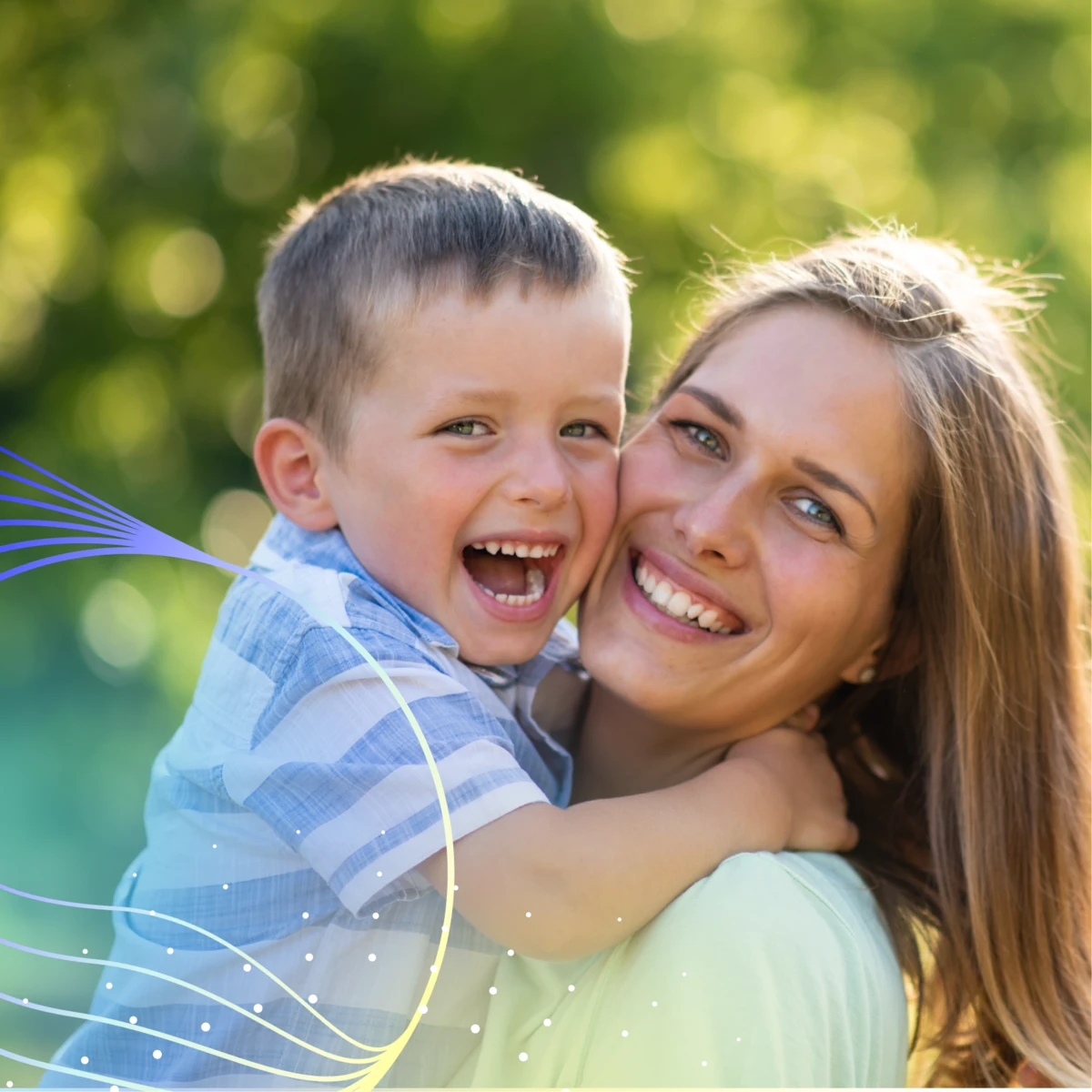 Mother smiling and holding young son, who is laughing
