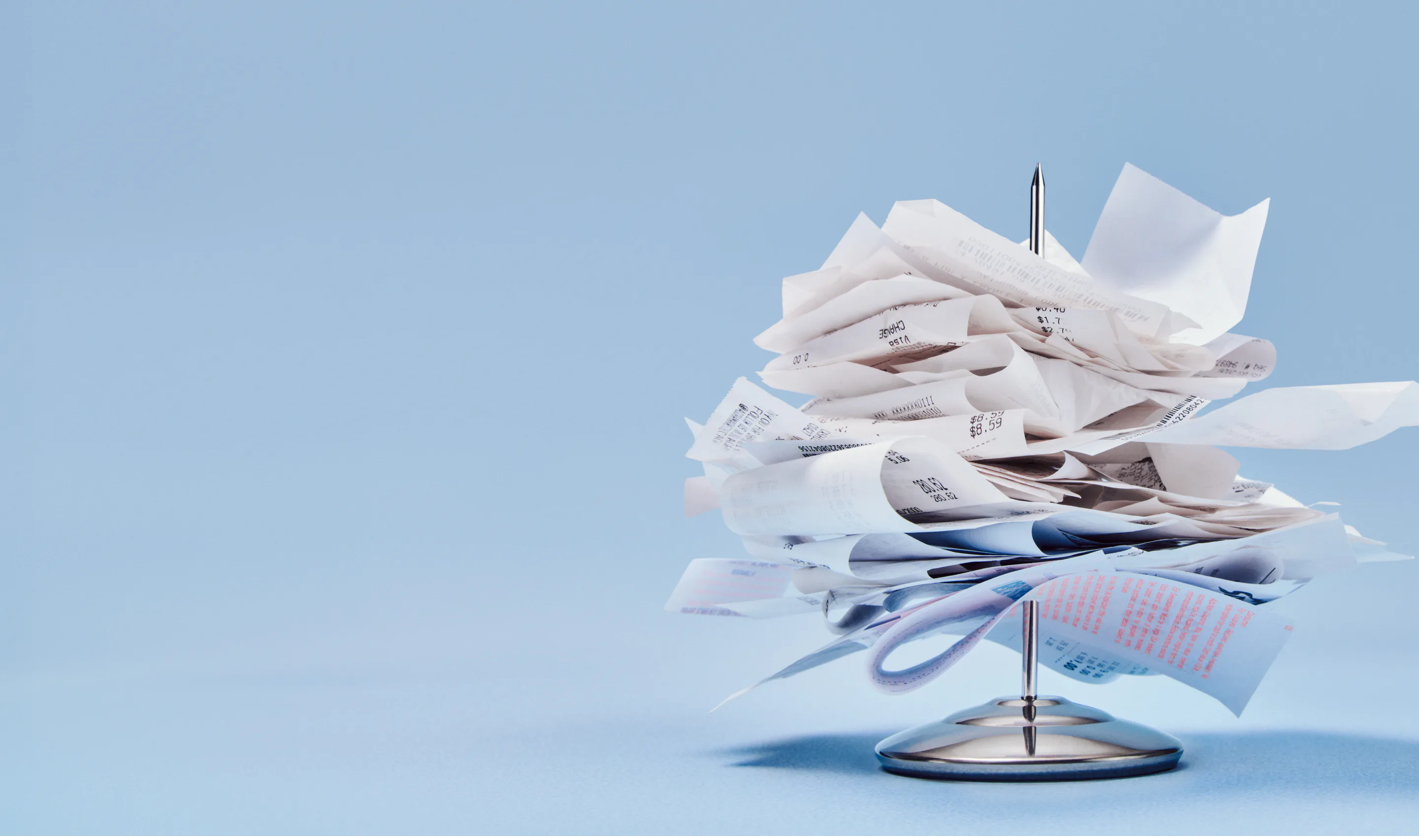A spike stacked with crumpled paper receipts