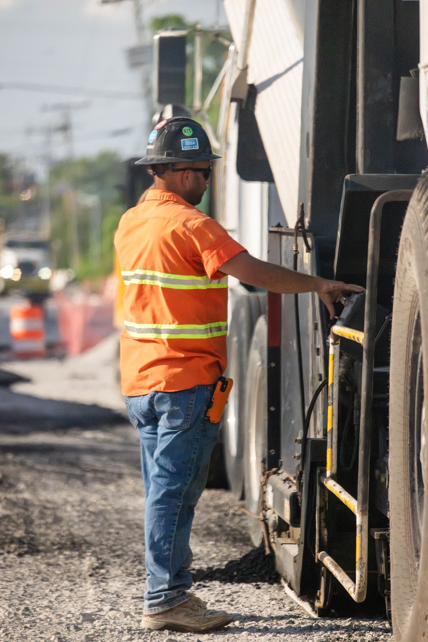 Close-up of yellow construction equipment with a PRD Pavement Restorations, Inc. sticker and a CAT logo.